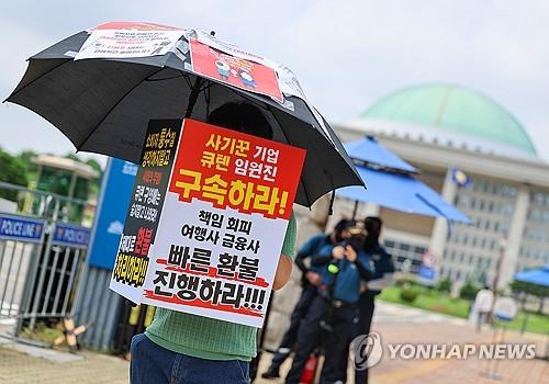 큐텐 구영배 대표, 류광진 티몬 대표, 류화현 위메프 대표 등이 국회 정무위 현안질의에 출석한 30일 오후 국회 앞에서 티몬·위메프 정산 지연 사태 피해자가 우산과 팻말을 들고 1인 시위를 하고 있다.