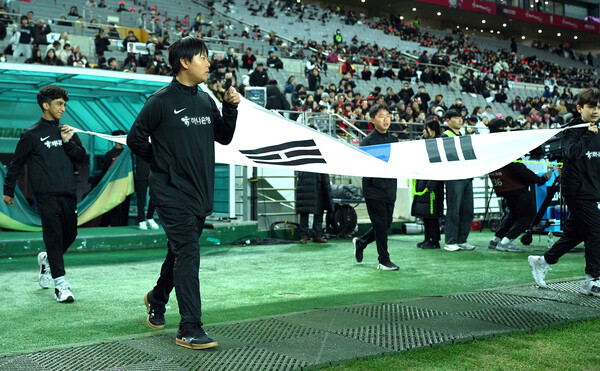 하나은행은 지난 18일 서울월드컵경기장에서 열린 대한민국과 가나의 축구 국가대표팀 A매치 경기에서 이주배경 가정 아동·청소년들에게 '매치볼 키드'와 '기수단'으로 참여할 수 있는 특별한 체험 기회를 제공했다고 밝혔다. 이날 '기수단'으로 참여한 아동·청소년들이 태극기를 들고 입장하고 있다
